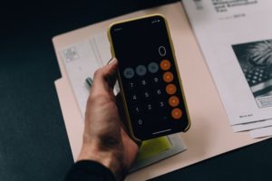 Person holding smartphone with calculator