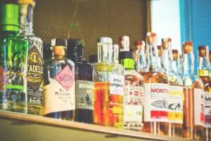 Image of alcohol bottles on a shelf - things to stop buying to save lots of money