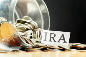 Image of jar and coins and a paper that reads IRA - ways to save money on a tight budget