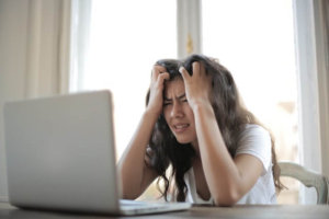 Woman frustrated at computer while tracking expenses