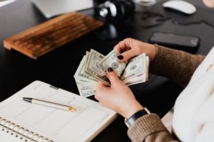 woman counting money and taking notes